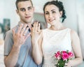 Defocused portrait of beautiful young couple female wife with small wedding pink flowers roses bouquet and male husband showing we