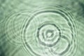 Defocused rippled transparent green water gel with concentric expanding circles on surface from fallen drop with waves Royalty Free Stock Photo