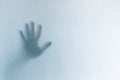 Defocused scary ghost hands behind a white glass background