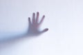 Defocused scary ghost hands behind a white glass background