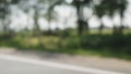 Defocused side view from a car of road suurounding trees Royalty Free Stock Photo