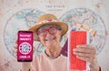 Defocused smiling senior woman holding mobile phone with green card passport, health certificate of vaccination of Covid-19 for