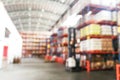 Defocused warehouse racks with cartons boxes as background