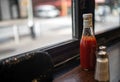 Ketchup bottle salt shaker and black evening bag in a diner window