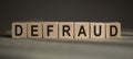 Defraud Word Written In Cubes on a black and grey background