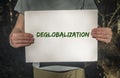 Deglobalization and reverse globalization concept. Word on paper placard in male hands with forest background