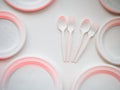 Degradable plastic forks and spoons and disks arranged on white