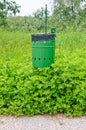 Degradation, trash can in the park in the middle of tall grass