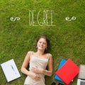 Degree against pretty student lying on grass Royalty Free Stock Photo