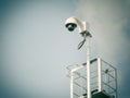 360 Degree fish eye dome CCTV is installed on column against blue sky.