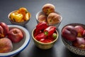 45 degree image of several assorted bowls of fresh and ripe nectarines, peaches and harvested red and yellow peppers Royalty Free Stock Photo