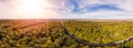180 degrees scenic landscape of countryside in beautiful autumn sunny day. Aerial drone view of road laid between oak forest Royalty Free Stock Photo