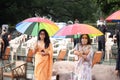 Beautiful ladies wearing mask, with umbrella in hands.