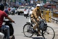 A Men riding bicycle wearing face mask