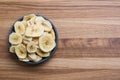 Dehydrated, dried banana chips on wooden board. View from above Royalty Free Stock Photo