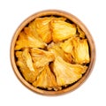 Dehydrated pineapple pieces, chunks of dried fruits, in a wooden bowl