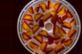 Dehydrating tray with goldenand red beet slices laid on top of a table with red linen