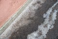 Deicing chemicals on pavement in winter. Salt grains on icy sidewalk paving slab with technical salt Royalty Free Stock Photo