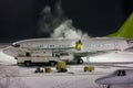 Deicing passenger plane at night