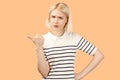 Dejected girl frown, feels unhappy, points with index finger leftward, being displeased see some item Royalty Free Stock Photo
