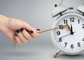Delay concept, time on alarm clock stop by hand Royalty Free Stock Photo