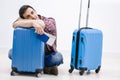 Delayed aeroplane concept. Tired passenger is napping on luggage in airport terminal and waiting for airplane arrival. Royalty Free Stock Photo