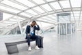 Delayed Flight Concept. Depressed Black Businessman Sitting With Suitcase At Airport Terminal Royalty Free Stock Photo