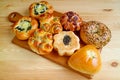 Delectable assorted sweet and savory breads on a wooden tray served on wooden table Royalty Free Stock Photo