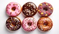 assorted donuts with chocolate frosted, pink glazed and sprinkles donuts.