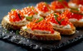 Delectable caviar-topped canapes made with crusty bread, a creamy spread, and glistening orange fish roe, garnished with
