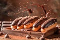 Delectable Chocolate Glazed Eclairs with Sprinkles on Rustic Wooden Table, Exquisite Pastry Delight, Culinary Indulgence Concept, Royalty Free Stock Photo