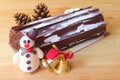 Chocolate Yule Log Cake with Blurry Dried Pine Cone and Christmas Decorations Royalty Free Stock Photo