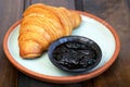 Delectable croissant sandwich and a sweet treat artfully arranged on a plate