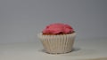 This delectable pink cupcake, adorned with a sprinkle of love