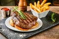 A delectable steak dinner with crispy fries and tangy sauces, perfect for a gourmet meal Royalty Free Stock Photo