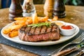 A delectable steak dinner with crispy fries and tangy sauces, perfect for a gourmet meal Royalty Free Stock Photo