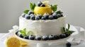 a delectable white cake adorned with slices of lemon, blueberries, and mint leaves, set against a pristine backdrop with