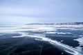 Deep crack in thick dark blue ice on frozen lake