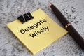 Delegate wisely text on sticky notes. Delegation of work concept