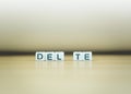 DELETE word written in cube on wooden floor on white background Royalty Free Stock Photo