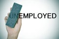 Deleting the prefix UN in the word unemployed with an eraser Royalty Free Stock Photo