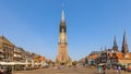 Delft Netherlands historical center market square with people sitting on terraces enjoying the beautiful weather.