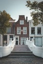Canal house in Delft and beautiful white bridge on the Voorstraat Royalty Free Stock Photo