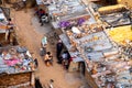 Aerial shot of people sitting wearing face masks outside their ramshakle temporary houses in a slum