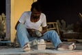 An Indian Marble Sculptor is sculpting a local Hindu deity with the help of modern grinding tool