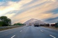 Empty indian highway with trucks and cars with long straight road leading to mountain in distance