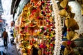Man walking past series of dangling decoration in chandni chowk in delhi