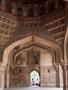 DELHI, INDIA - MARCH 13, 2019: interior view of a bara gumbad window and an indian couple sitting on it