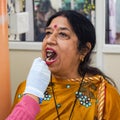 Delhi, India - November 19, 2022 - Close up of female dentist doing routine dental check-up to patient, Patient lying on chair at