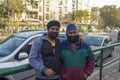 Two indian bearded men in blue turbans hugging against the background of the city road Royalty Free Stock Photo